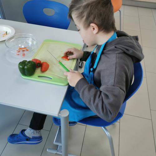 ein Schüler schneidet Gemüse