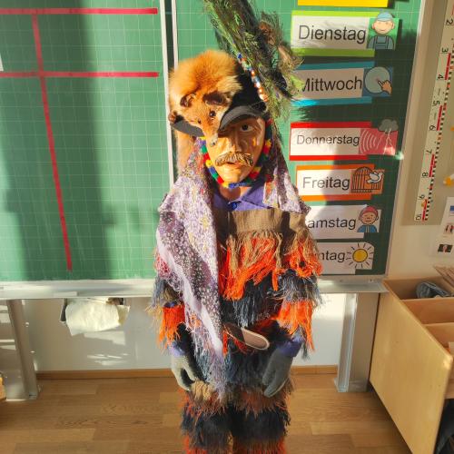 Ein Kostümierter mit Maske und Pelz