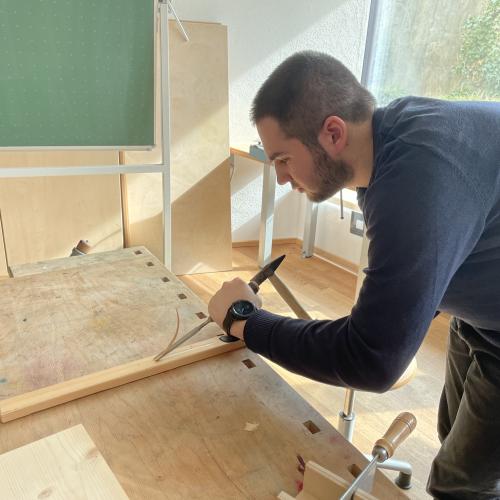 Ein Schüler arbeitet mit Hammer und Meißel