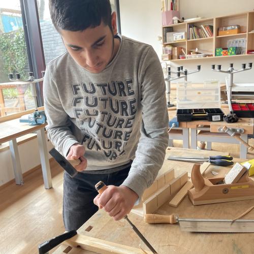 Ein Schüler probiert Hammer und Meißel aus
